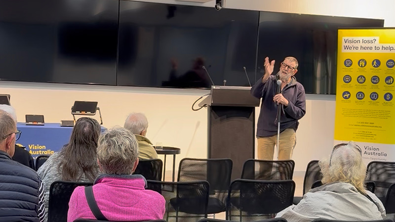 A user of Meta AI glasses presents to attendees at a Vision Store technology expo.